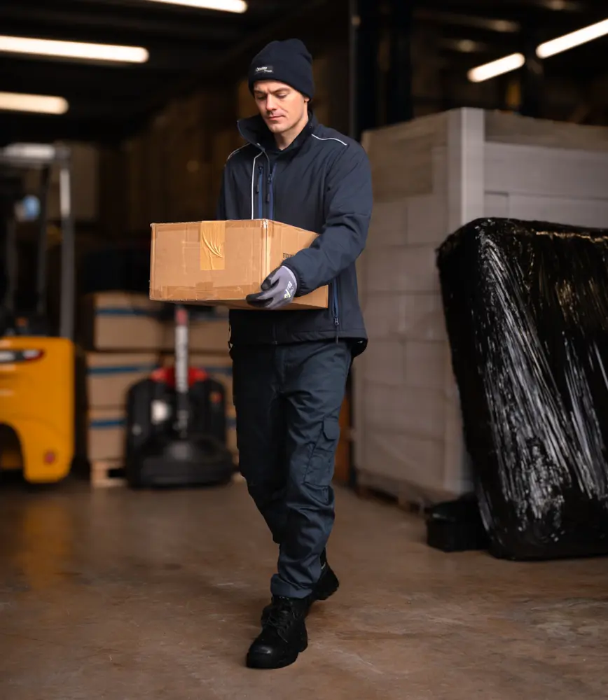 Warehouse worker carrying a box while wearing durable embroidered workwear by Atire